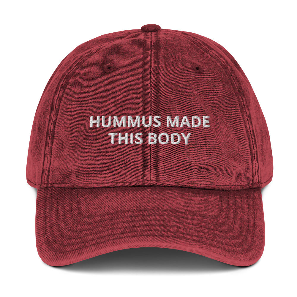 Maroon Hummus Made This Body Hat - Our Hummus Made This Body Hat is comfortable, has an adjustable closure, and is made just for you. It's a classic dad hat with a hummus saying embroidered on the front.